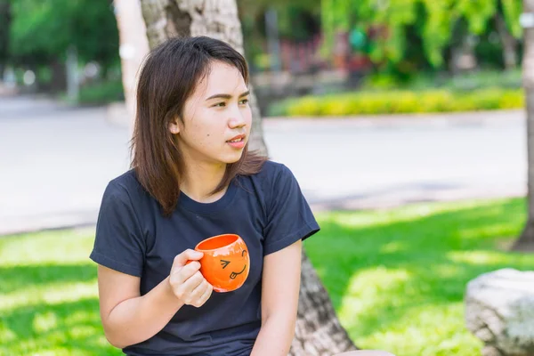 Aziatische tiener holding smiley mok genieten van koffie in de ochtend drinken — Stockfoto
