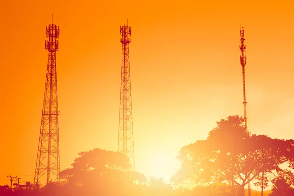 剪影日落黄昏橙色的天空上的多个波段电话 cellsite 塔天线 — 图库照片