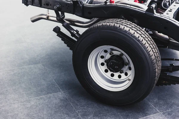 Primer plano camioneta neumático trasero con chasis de coche parte inferior limpio nuevo de fábrica — Foto de Stock