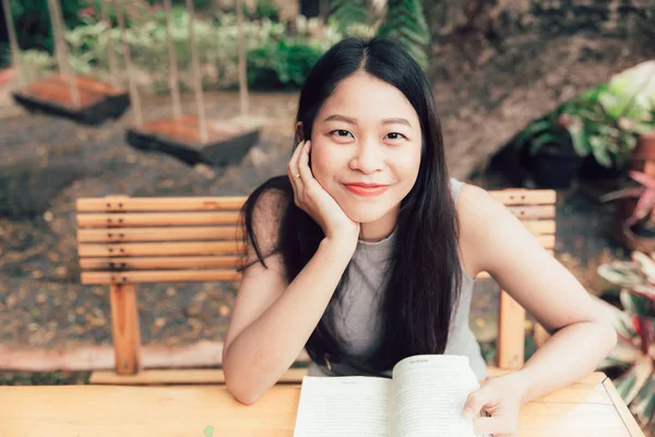 Geniet van ontspannen tijden met leesboek, Aziatische vrouwen Thaise tiener glimlach met boek in coffeeshop vintage kleurtoon — Stockfoto
