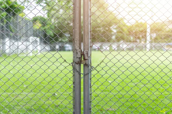Closed sport field with lock or public park close protect green concept — Stock Photo, Image