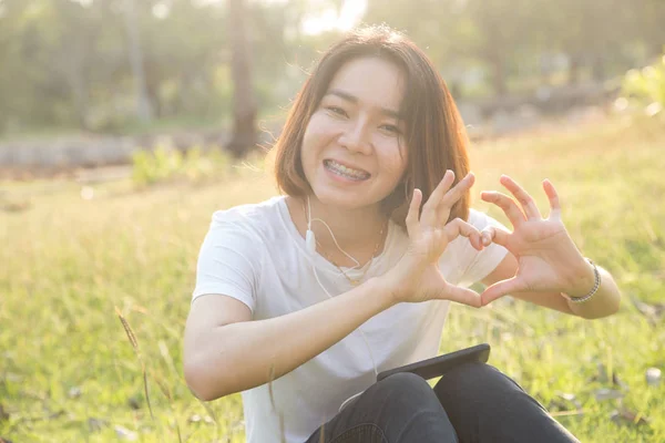 かわいいタイのアジアの女の子は恋日差しの中で彼女の手のハート — ストック写真