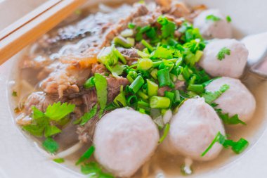 Yakın çekim Tay Çin çorbası noodle sığır köftesi ile soğan yaprakları ve kişniş ile süslenmiş