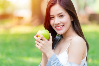 Güzel Asyalı kadınlar modeli elini tut yeşil elma park açık sağlıklı beslenme organik gıda meyve diyet kavramında