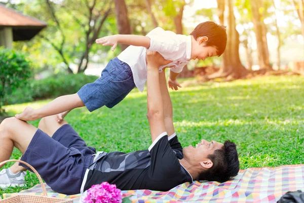 Good Daddy and Son concept: Father play flying with his boy in the park