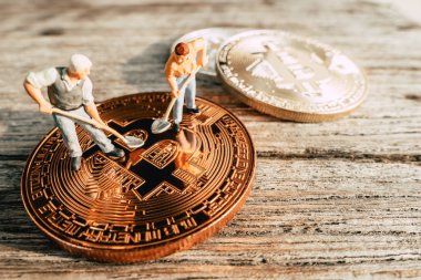 Değerli madeni para ahşap arka plan üzerinde kazma Bitcoin madenciliği minyatür insanlar