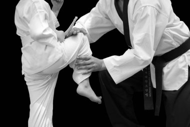Adam öğretim Taekwondo Fighter çocuk denge durmak için siyah arka plan üzerine uçuş