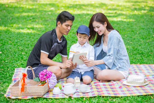 Parents as Teachers concept: Teen family with one kid happy education moment in the park.