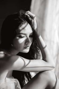 Yalnız ve yalnız seksi kadınlar üzgün bir şekilde pencerede oturuyorlar. Siyah ve Beyaz Monoton Sanat Fotoğrafı.