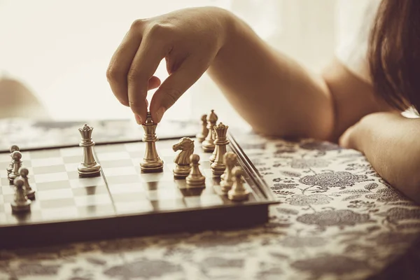 hand playing chess board game vintage color tone.