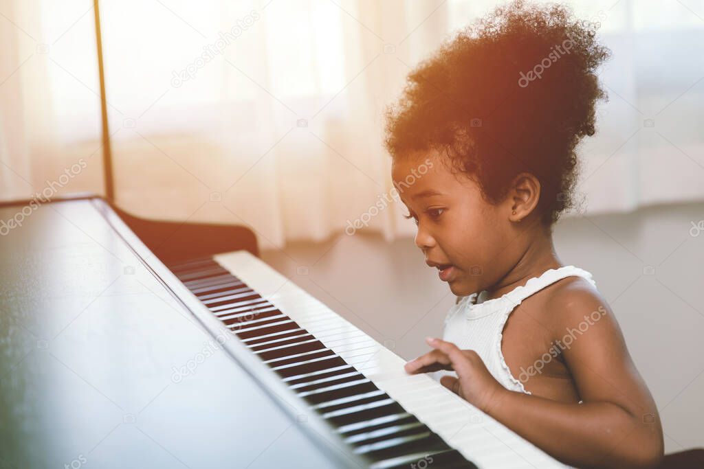 children girl playing piano looking exciting happy and enjoy with music instrument and be player