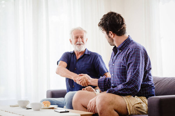 elder hand shaking dealing with a man indoor shot