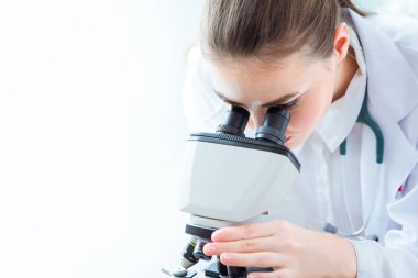 Tıp doktoru bilim laboratuarındaki mikroskoba bakıyor Wuhan kavramından yeni Coronavirüs.