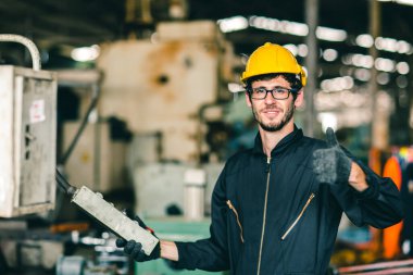 Gözlüklü inek işçi parmağını göster. Fabrikada çalışmaktan mutlu ol. Endüstriyel mühendis adam makineyi çalıştırmayı sever..