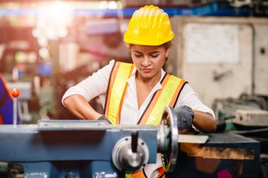 Genç işçi Afro-Amerikan işçi kız ağır çelik makinesiyle sanayi fabrikasında çalışıyor..