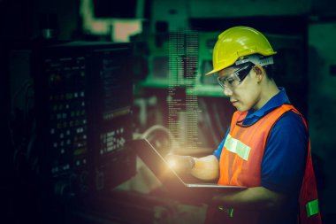 İşçi Cnc makinesini G-Code monitörüyle çalıştırıyor, yüksek beceri gerektiren iş endüstrisi güvenlik elbiseleriyle yüksek teknoloji becerisi için koyu yeşil renk tonuyla.