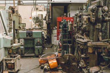 Eski grunge kullanılmış makine atölyesi garajı ya da ağır makine hurdalığı tehlikeli işyeri.