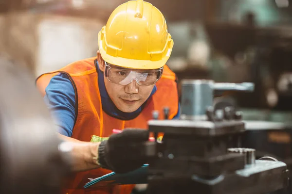 安全スーツのヘルメットと目の保護メガネを身に着けているアジアの中国のエンジニアの労働者は 工場での作業検査と生産プロセスのチェックに焦点を当てる — ストック写真