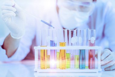 Bilim adamı doktor tüp içinde bir çok kimyasal reaksiyon testini inceledi. Tıp laboratuarında ilaç formülü testinde çalışıyorum.