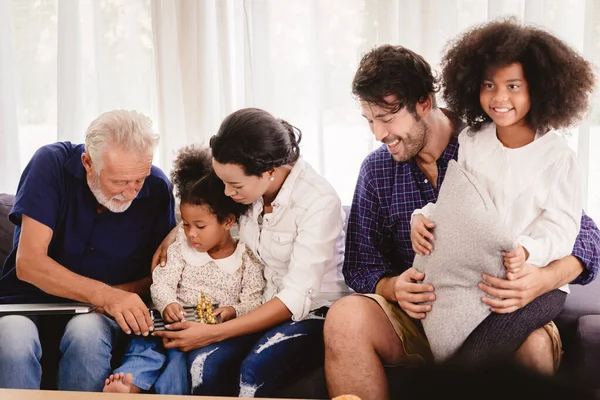 Lovely home happy family living together in living room father mother and grandfather playing with daughter mix race.