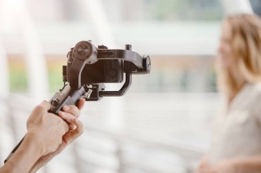 Dengeleyici video sahnesi için dslr kamera anti-sallama aracı kullanan motorlu gimbal ve videograf.