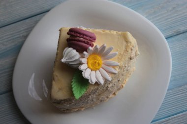 Tabakta papatya çayı şeklinde süslemesi olan bir parça pasta..