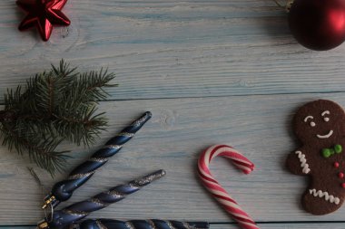 Kızıl adam, baston ve ladin dalları ahşap bir arka planda.