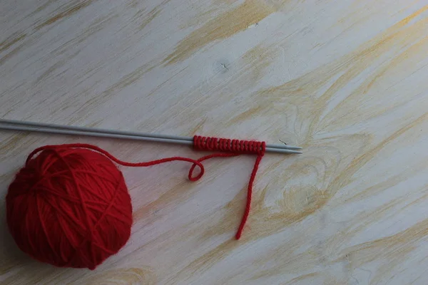テーブルの上に赤い糸と編み針のボール — ストック写真