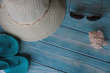 Mavi tahta şapkalı, güneş gözlüklü ve yaz ayakkabılı yaz aksesuarları..
