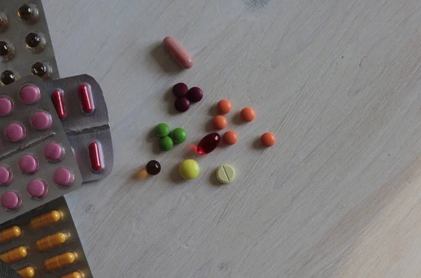 Tablets, capsules and vitamins are in blisters and are on the table.