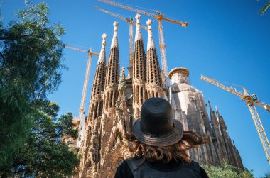 Barcelona'da Sagrada Familia şapkalı bir gezgin bakar