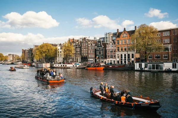 Local people and tourists dressed in orange clothes ride on boats and participate in celebrating King's Day — Stock Photo, Image