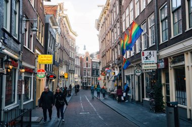 Amsterdam tarihi kent parçası dar bir cadde boyunca yürüyen turist.