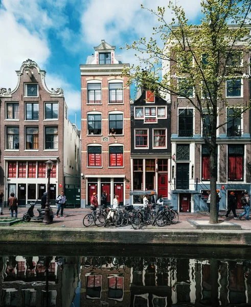 Типичные узкие дома с большими окнами и каналами с отражением, Амстердам, Нидерланды . — стоковое фото