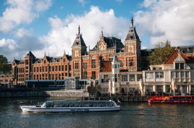 Cityscape merkez tren istasyonu ve eski şehir kanalı ile Turistik gemiler, Amsterdam, Hollanda