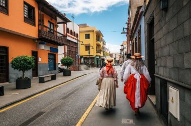 Yerliler Kanarya geleneksel giysiler içinde Puerto de la Cruz'daki cadde boyunca yürümek. Kanarya Adaları günü. Tenerife.