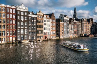 Turist Damrak kanalına Amsterdam'da batımında mavi yolculuk.