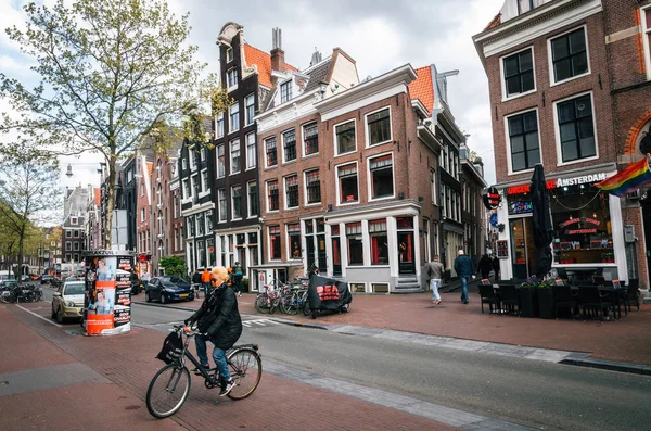 Adult woman rides a bicycle in red light district of Amsterdam, Netherlands — Stock Photo, Image