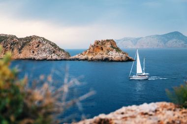 Yacht sails at Mediterranean sea between cliffs, Mallorca clipart