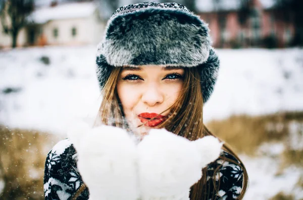Молодая женщина, дующая снег — стоковое фото