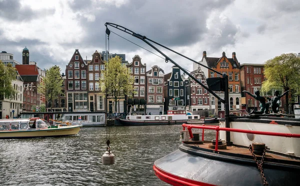 Cruise tourist boat in Damrak canal in Amsterdam at sunset. — Stock Photo, Image