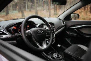 Lada Vesta Sonbahar Ormanı 'ndaki kır yolunda bir robot.