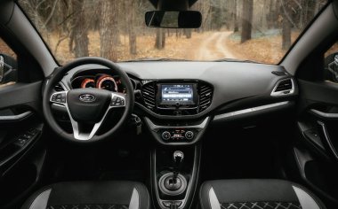 Lada Vesta Sonbahar Ormanı 'ndaki kır yolunda bir robot.