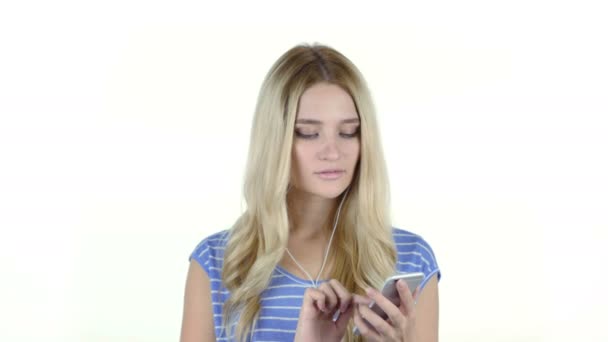 Jong meisje, luisteren naar muziek met koptelefoon, witte achtergrond — Stockvideo
