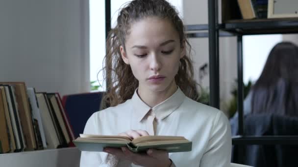 Mujer leyendo libro en la oficina — Vídeos de Stock