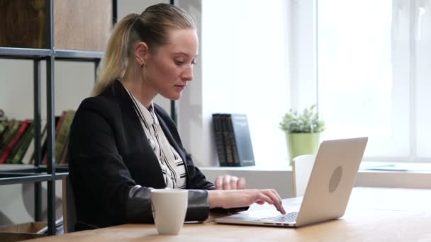 Отмечая успех, взволнованная деловая женщина работает на ноутбуке — стоковое видео