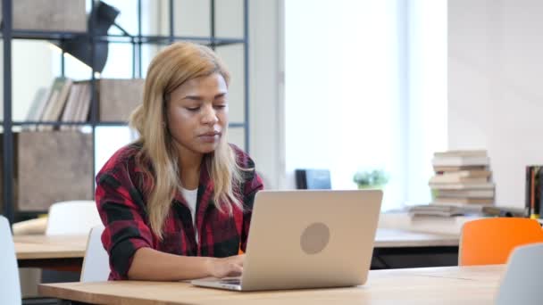 Černá žena pracující na notebooku, usmíval se směrem k fotoaparátu — Stock video