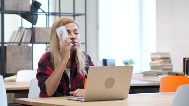 Donna nera che parla su smartphone, seduta in ufficio — Video Stock