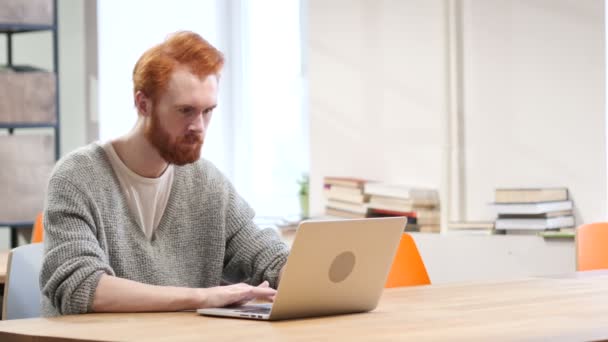 Возбужденный человек празднует успех, работает над ноутбуком — стоковое видео