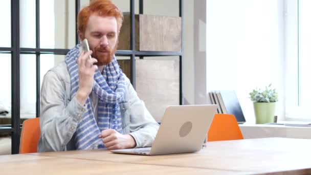 Telefon vyjednávání muž při práci na notebooku — Stock video